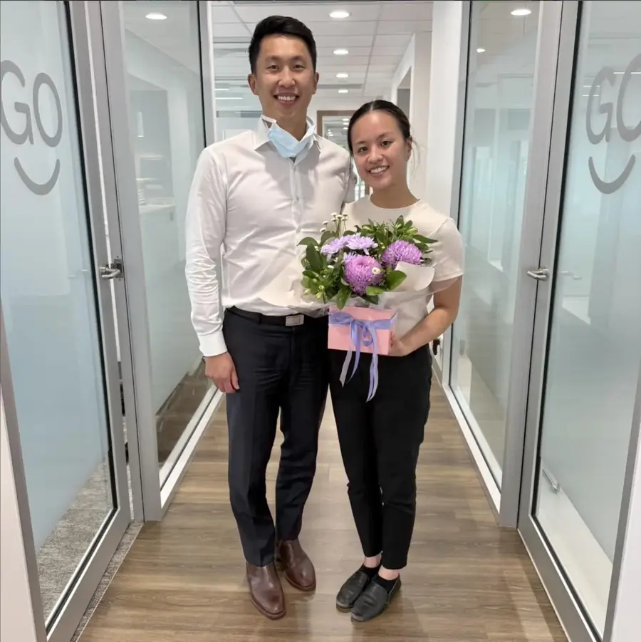 Dr Shaun Goh presenting flowers to a Go Orthodontics team member